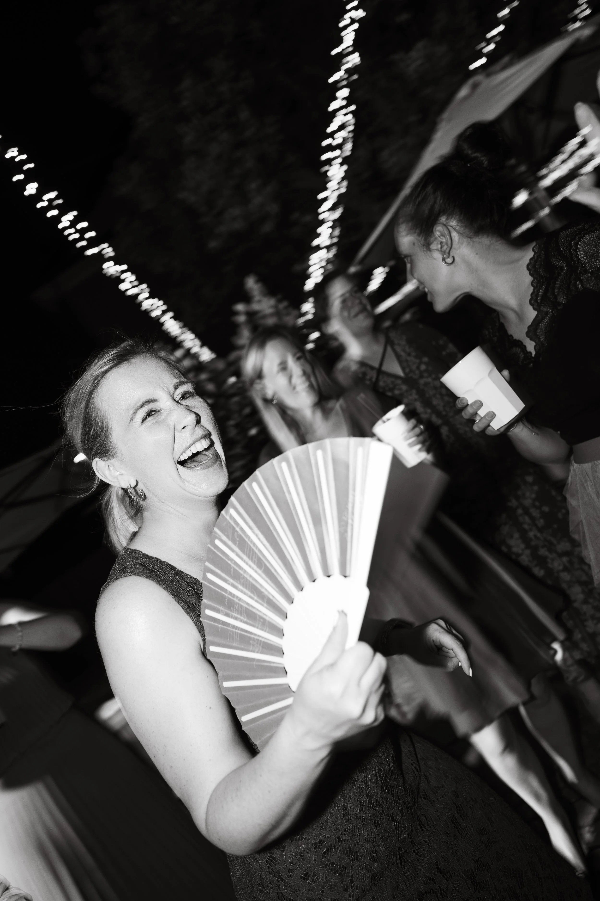 wedding party, a woman smiles with a fan in the hand. langhe wedding.