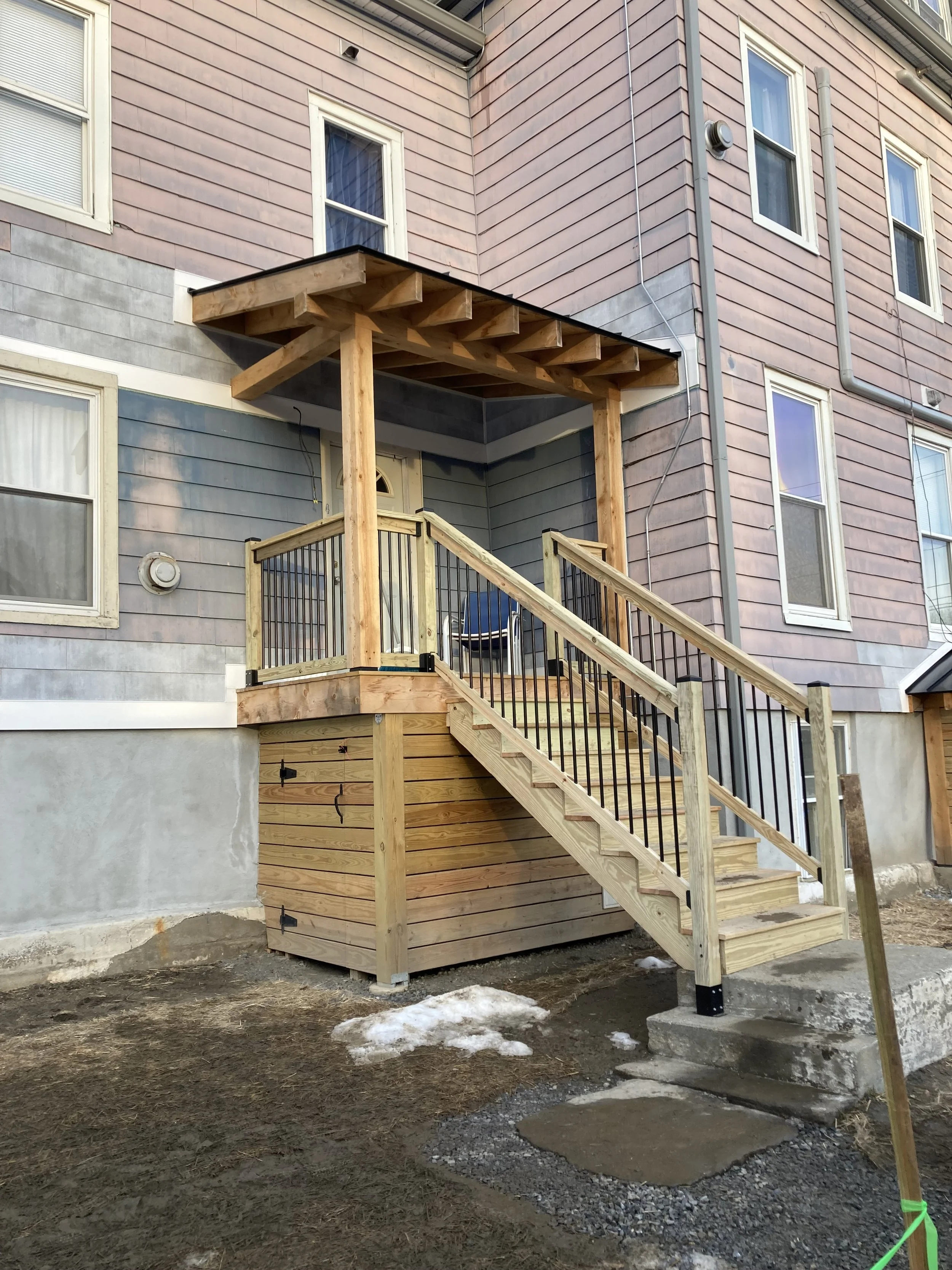 New post and beam porch built with local rough-sawn hemlock.  Standing seam roof.  Essex, VT