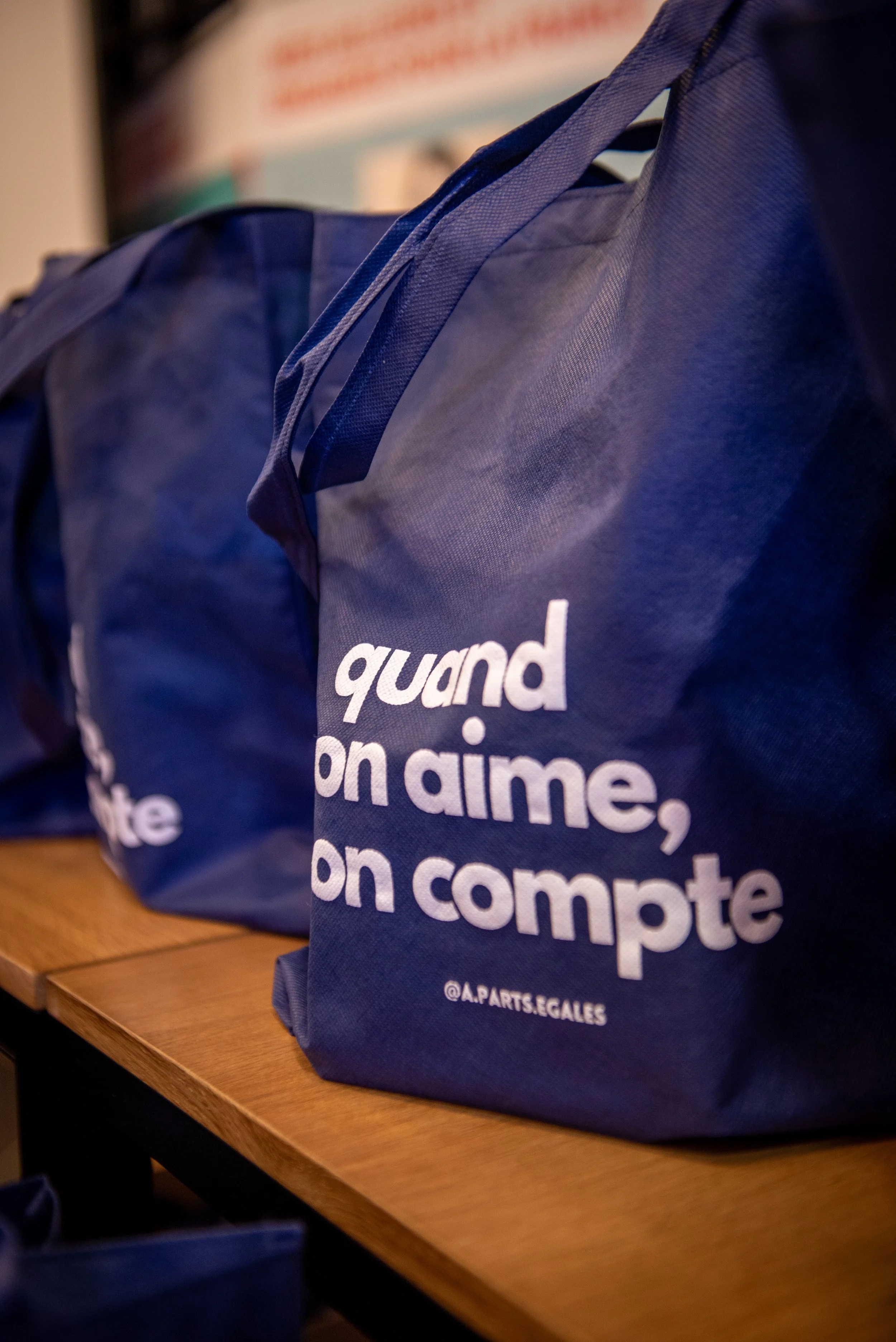 Sacs en tissu bleu avec le texte en français : 'quand on aime, on compte'.
