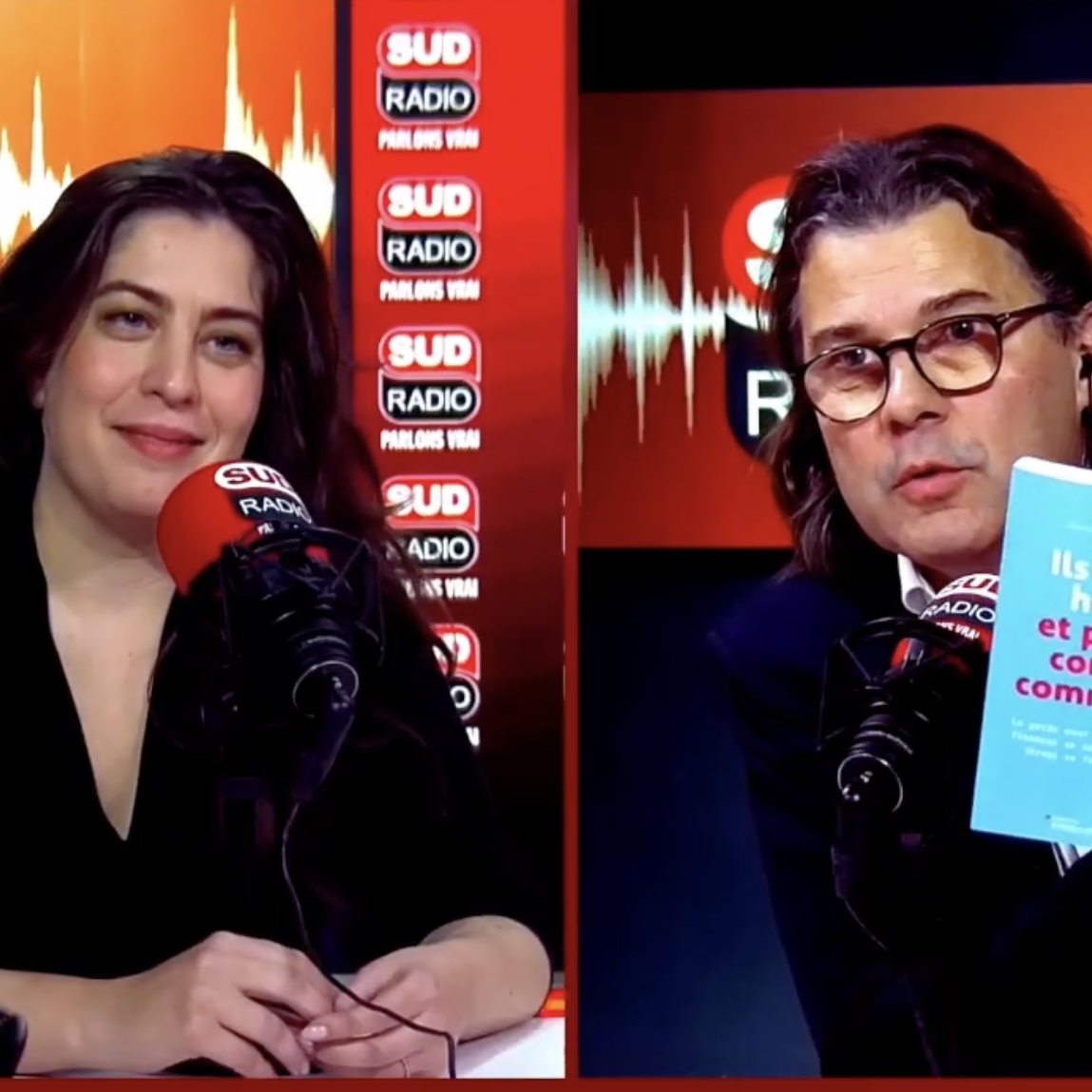 Deux personnes en studio de radio, un homme avec des lunettes et une femme, chacun devant un microphone portant le logo SUD RADIO, avec des arrière-plans rouges et des logos de la station de radio.
