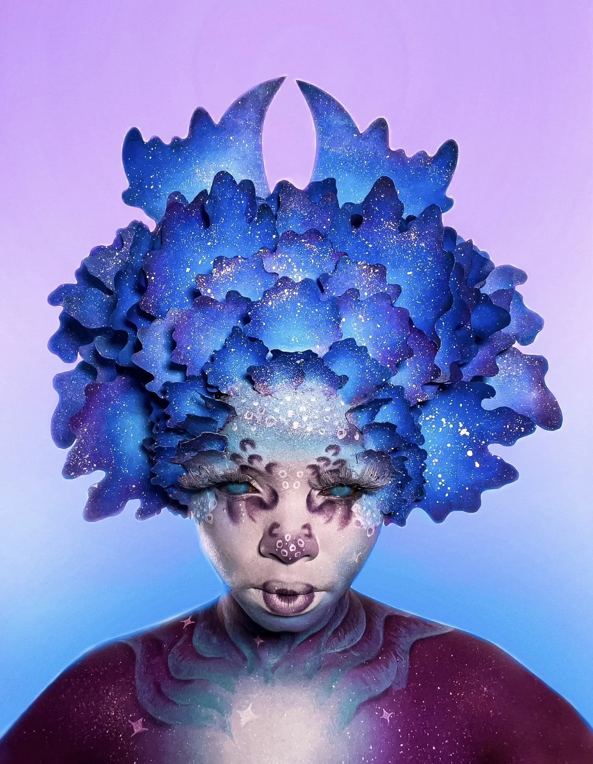 Desree's make up look inspired by the Aurora Borealis, featuring a mesmerising dance of blues, purples, and whites that mirror the colours of the Northern Lights and a headpiece inspired by the gyrfalcon's wings.