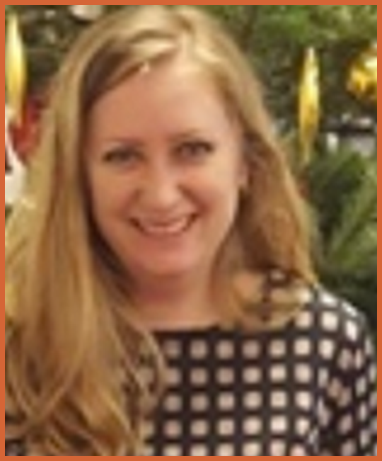 A woman with long blonde hair smiling at the camera, wearing a black and white checked top, with a blurred outdoor background.