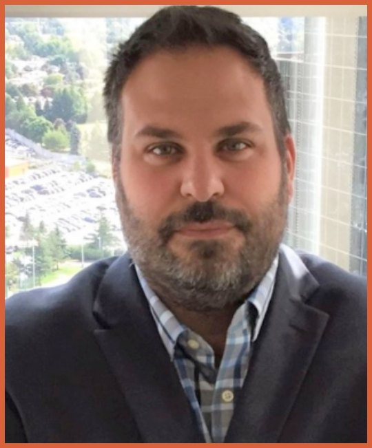Portrait of a man in a suit with a busy cityscape in the background.
