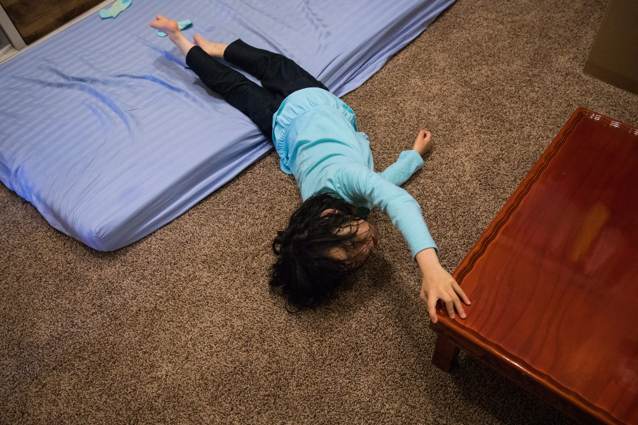 Yuna exploring her mother’s closet after her bath. Her mother, Soo-Kyung, began sleeping on the mattress after she collapsed from the stress of caring for Yuna; sleeping in the closet helps Soo-Kyung rest without noise or distraction.CreditRuth Frem…