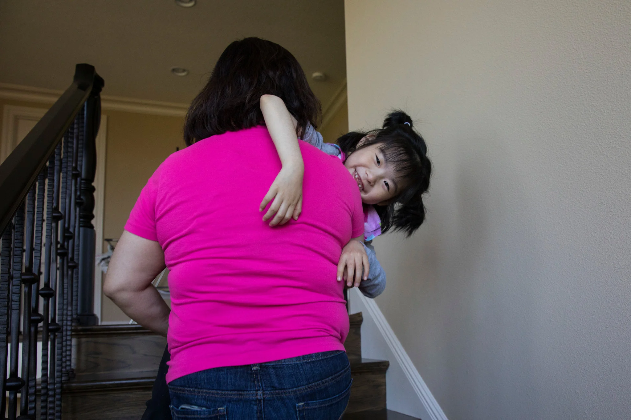 As Yuna, in the arms of her caregiver, Anne Marie Nguyen, grows, it gets harder to carry her up and down the house’s several flights of stairs.CreditRuth Fremson/The New York Times