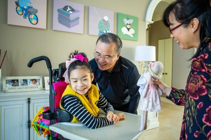Yuna flashes a big smile as she plays with her father, Jae Lee, and mother, Soo-Kyung Lee (right), who both are biology researchers at UB. Photo: Douglas Levere