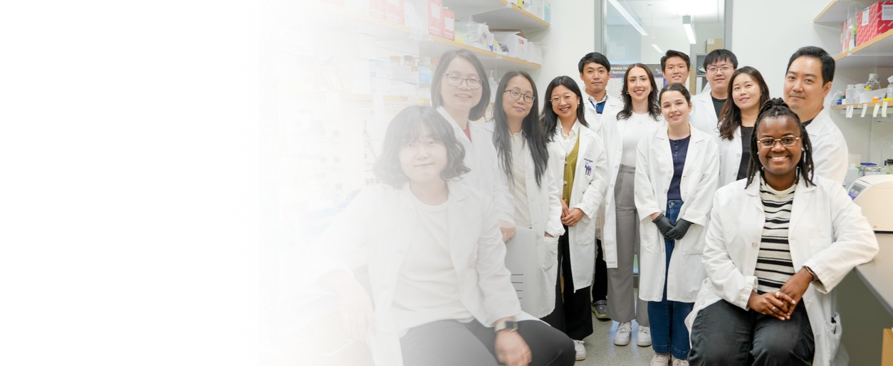 Group of diverse scientists in lab coats standing and sitting in a laboratory.