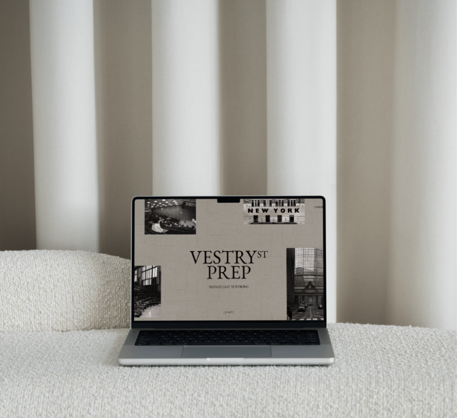 Laptop computer on a beige textured sofa, displaying a website or presentation titled "Vestryst Prep Private LSAT Tutoring" with black and white images in the background.