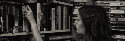 A woman browsing books on a library shelf