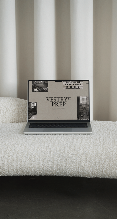 Laptop on a textured beige surface with a curtain background, displaying a webpage titled 'VESYTRST PREP' related to apartment tutoring.