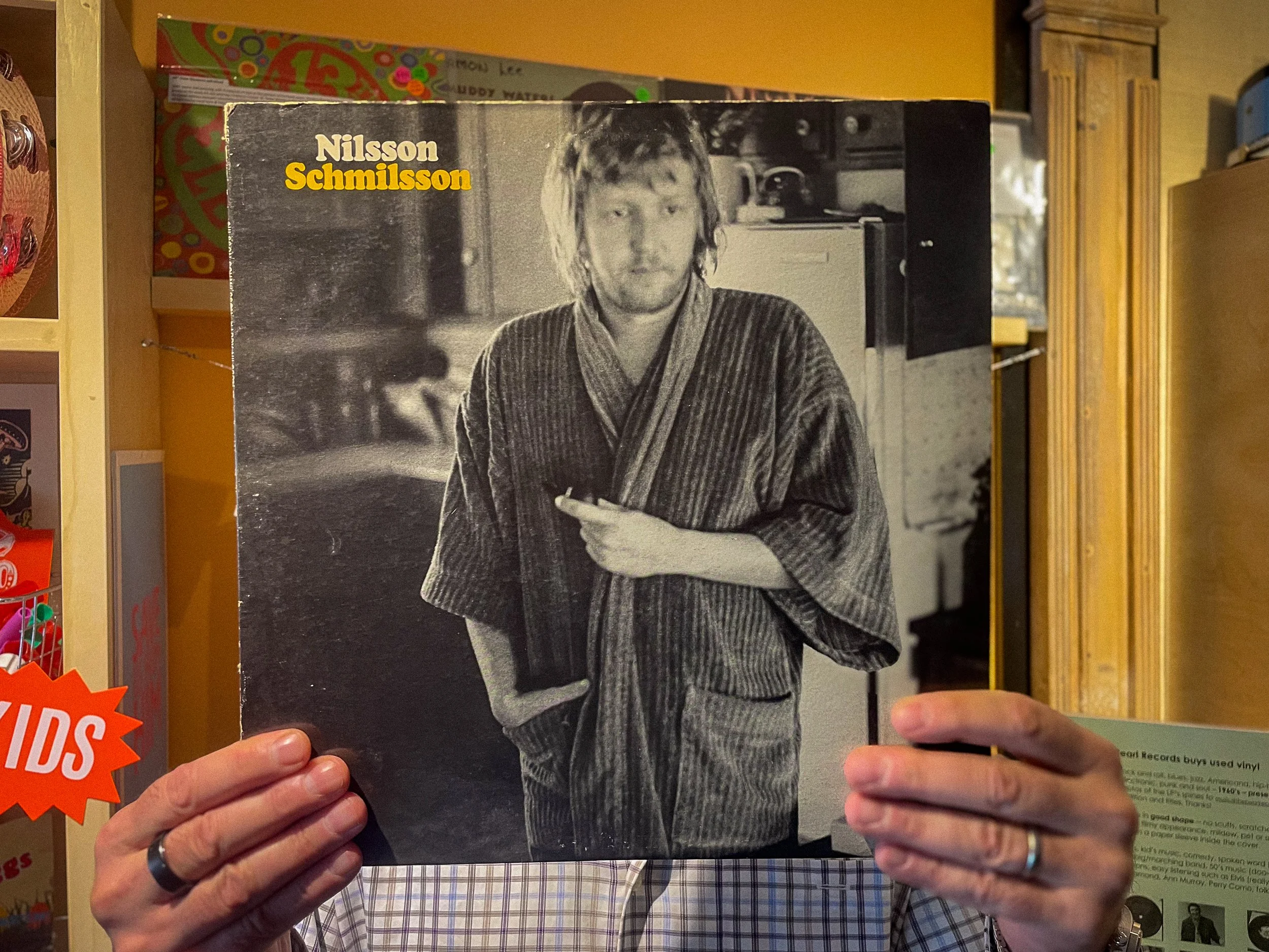 Photograph of customer holding Harry Nilsson's Nilsson Schmilsson record.