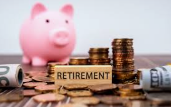 Pink piggy bank, stacks of coins, and a wooden block with 'RETIREMENT' written on it