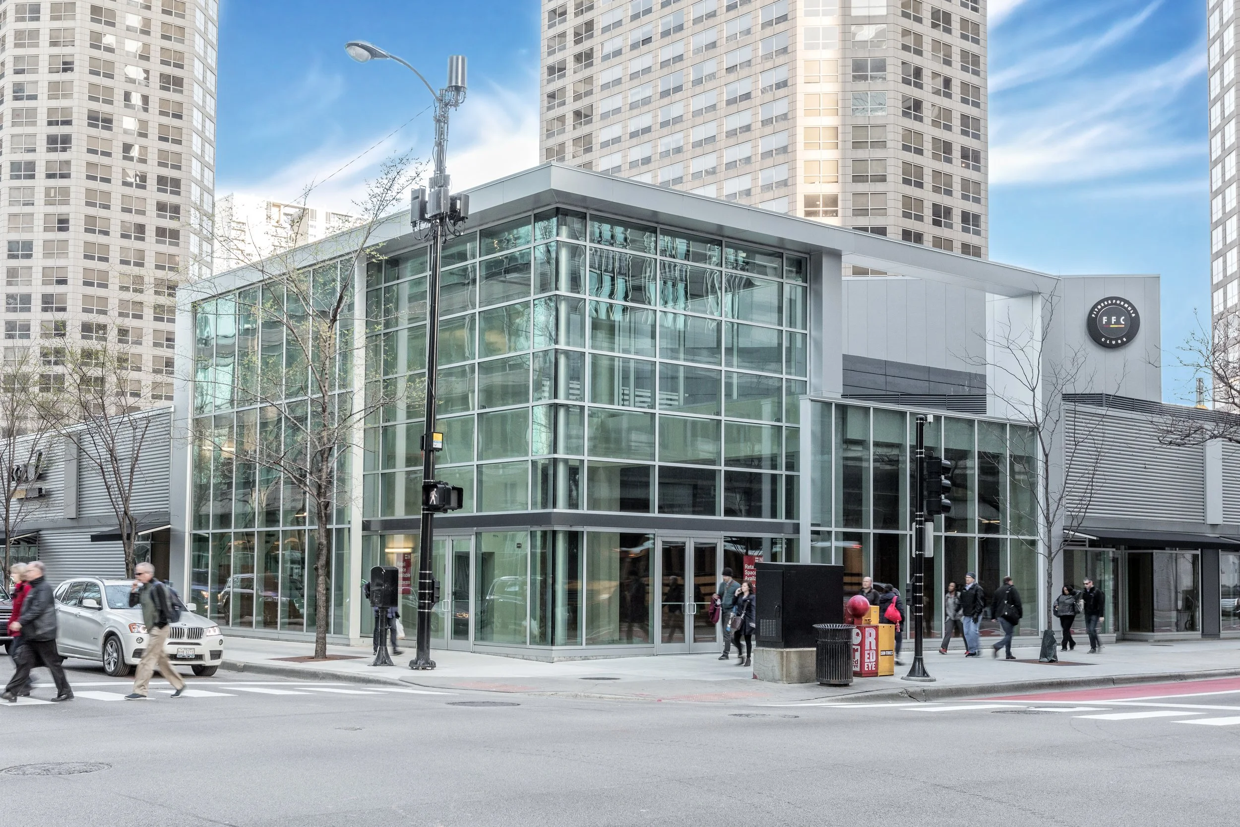 Entryway to FFC Gym at Presidential Towers, Chicago, a modern glass‑and‑steel fitness space on a city street.