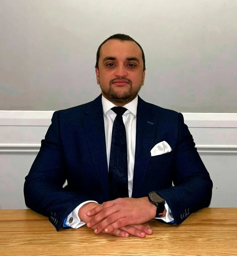 A batty man dressing up in a three piece suit in his kitchen thinking hes don one.