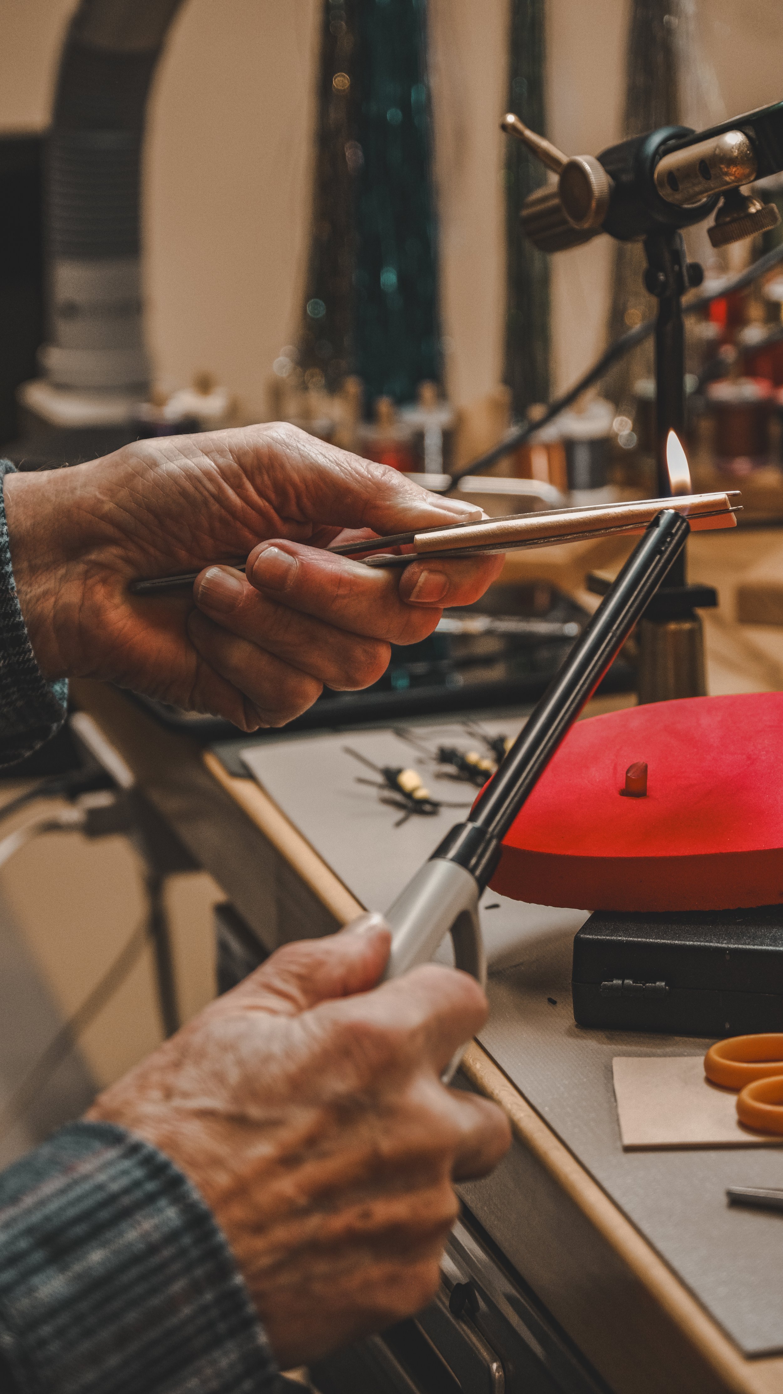 A person using a blowtorch on a metal object in a workshop.