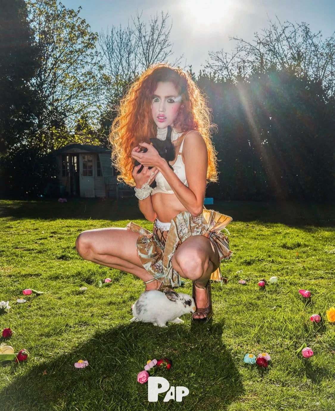 Fashion lookbook: Styling assistance for an Easter-themed shoot illustrating curly red hair, a black rabbit, and ruffled cream textures.