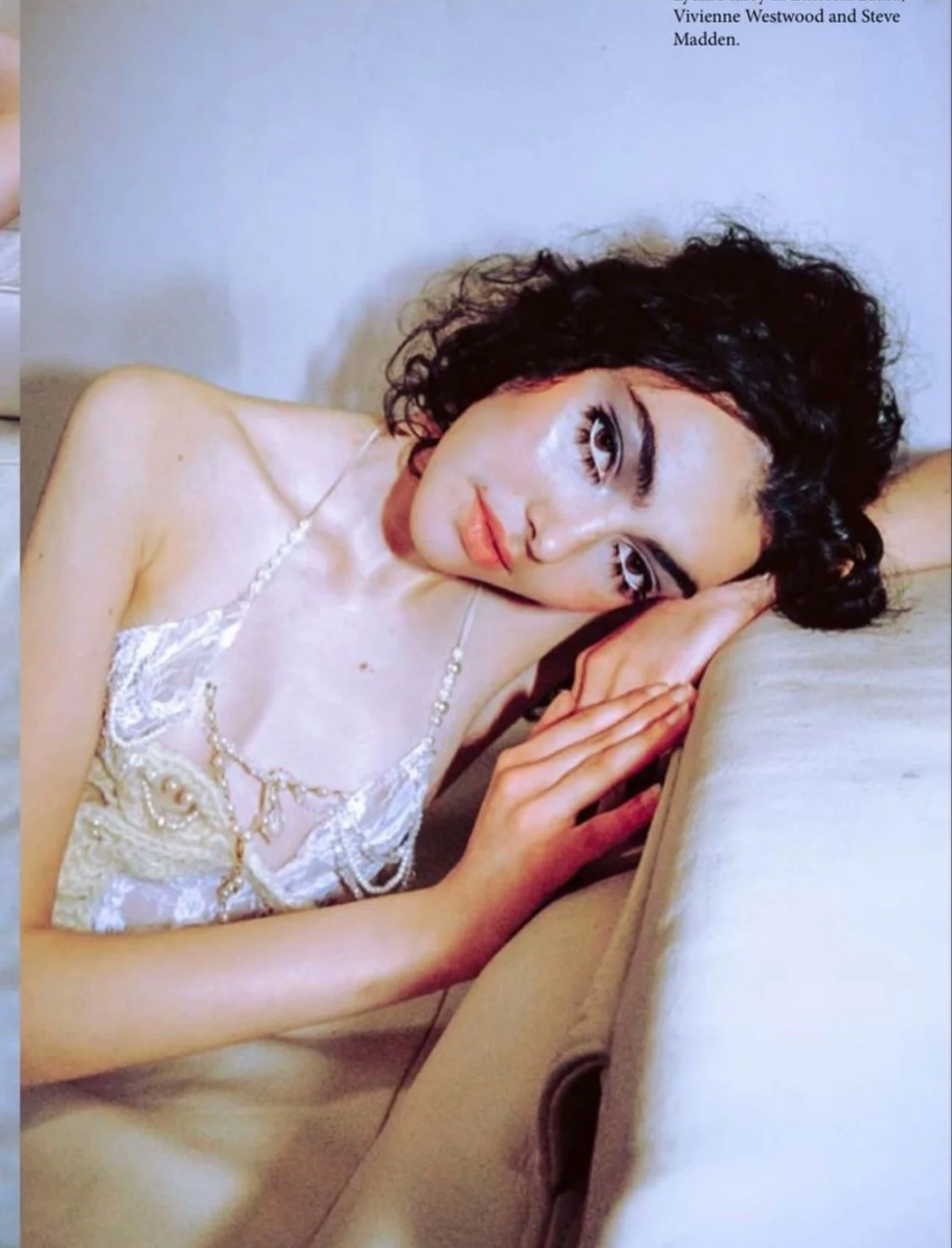 Interior fashion editorial: Contemplative styling featuring a delicate white lace dress and jewelry, showcasing a soft, ethereal aesthetic.