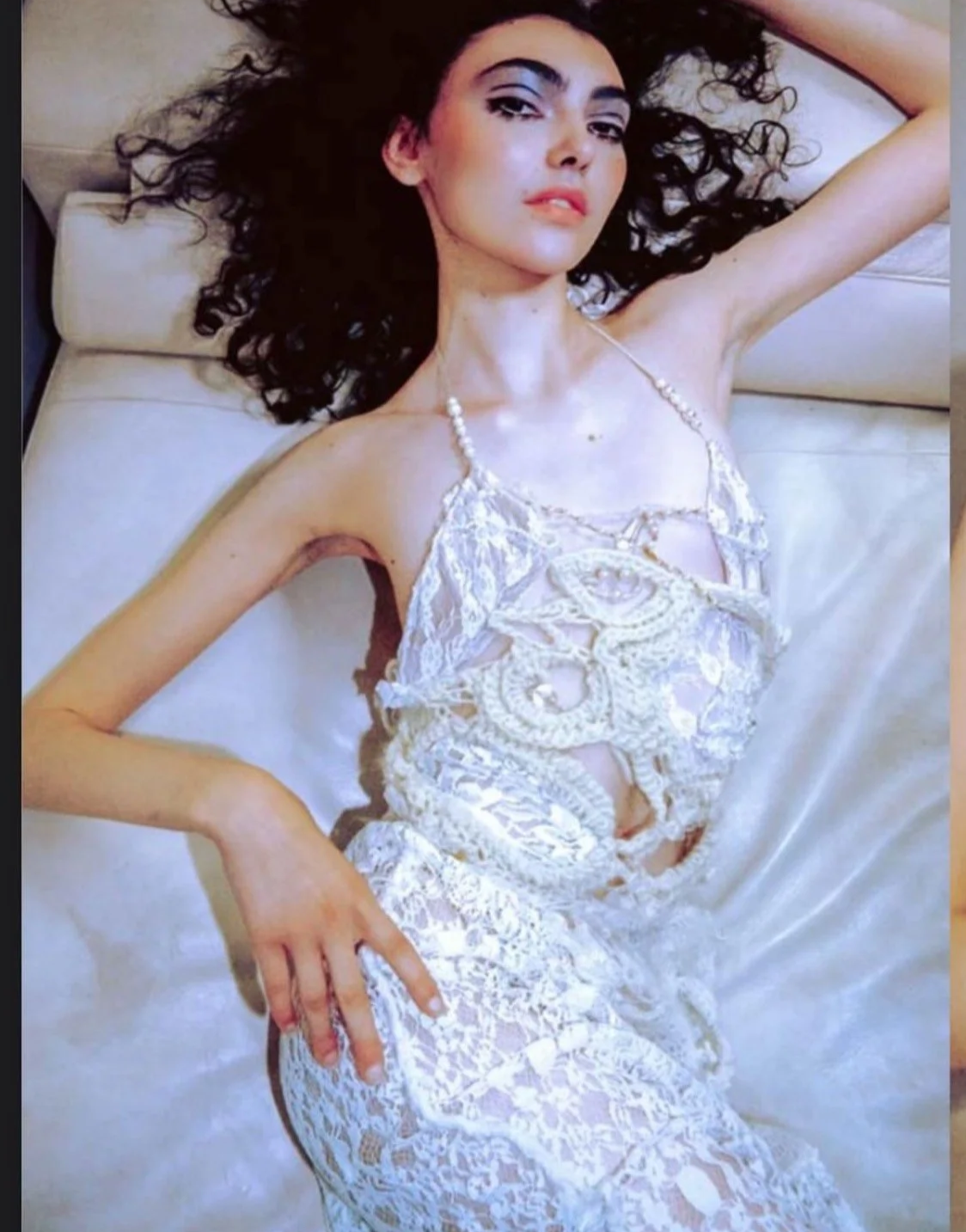 Fashion editorial portrait: A study in delicate textures featuring a white lace dress and pearl necklace, styling assistance by Mara Bernemann.