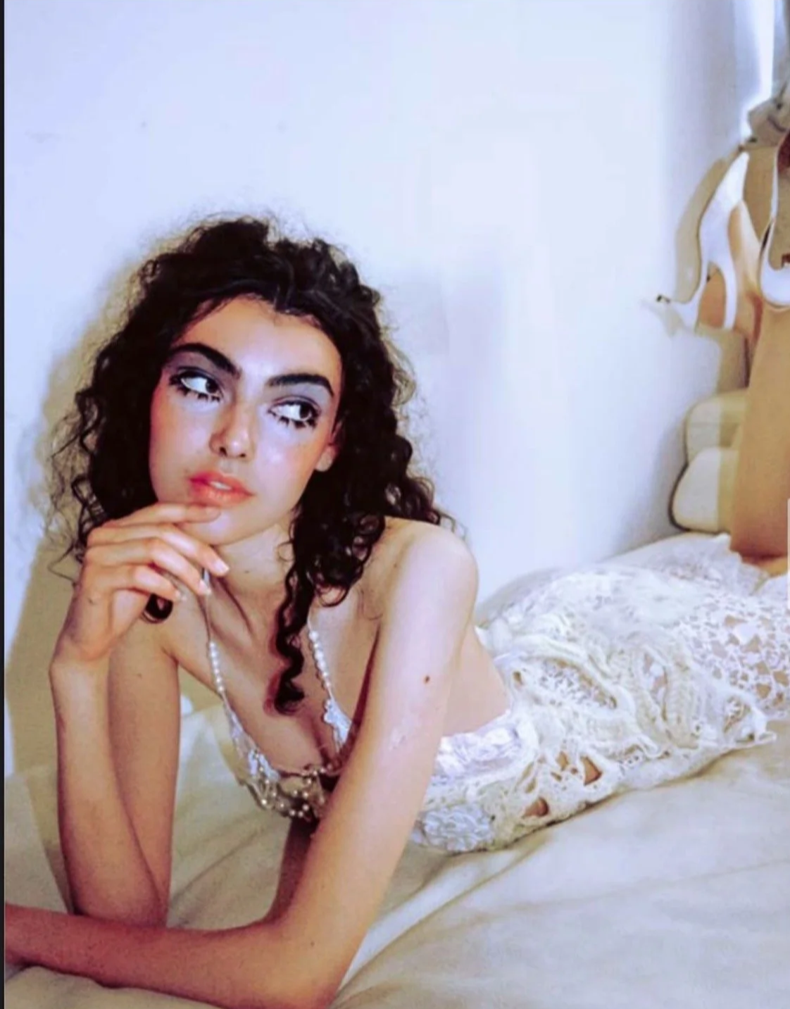 Soft-aesthetic fashion story: Model in a white lace dress and pearl accessories, illustrating a quiet, contemplative mood.