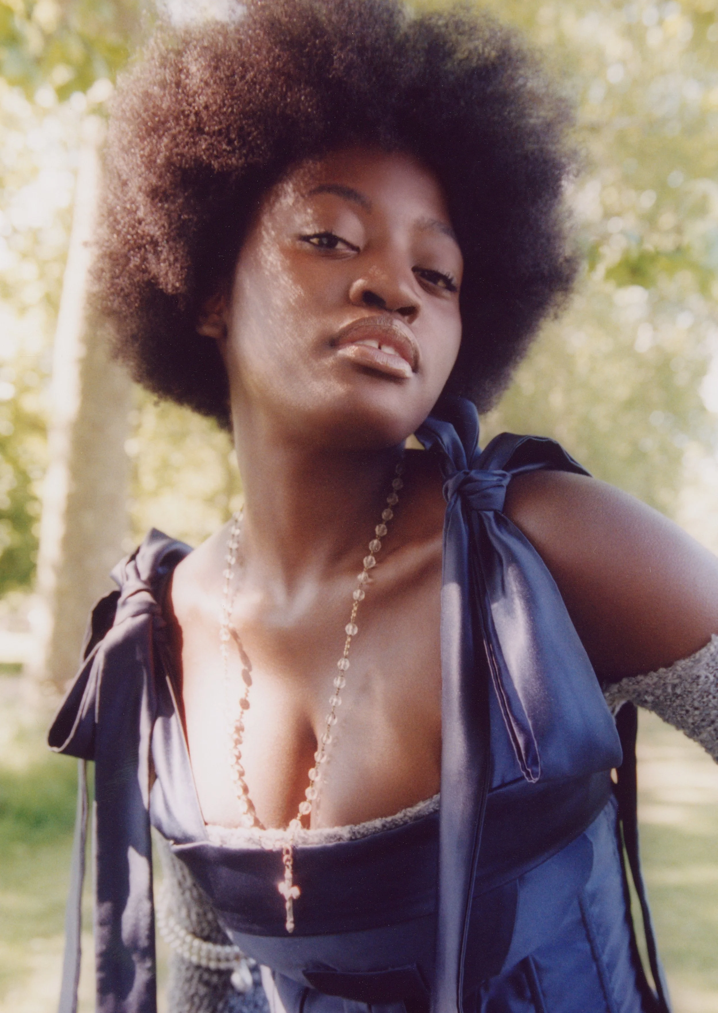 Contemporary romanticism: Navy blue corset with ribbon-tie details and layered hardware in a natural field setting.