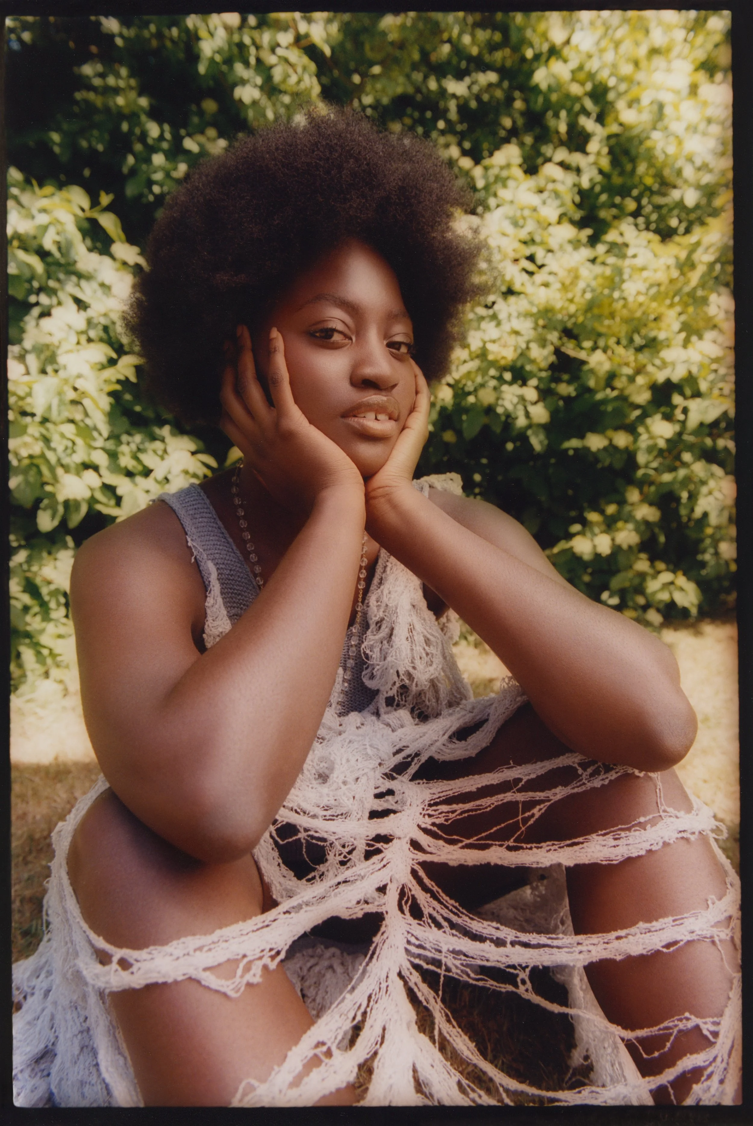 Natural light portraiture: Distressed white lace styling featuring artisanal jewelry, set within a lush garden environment.
