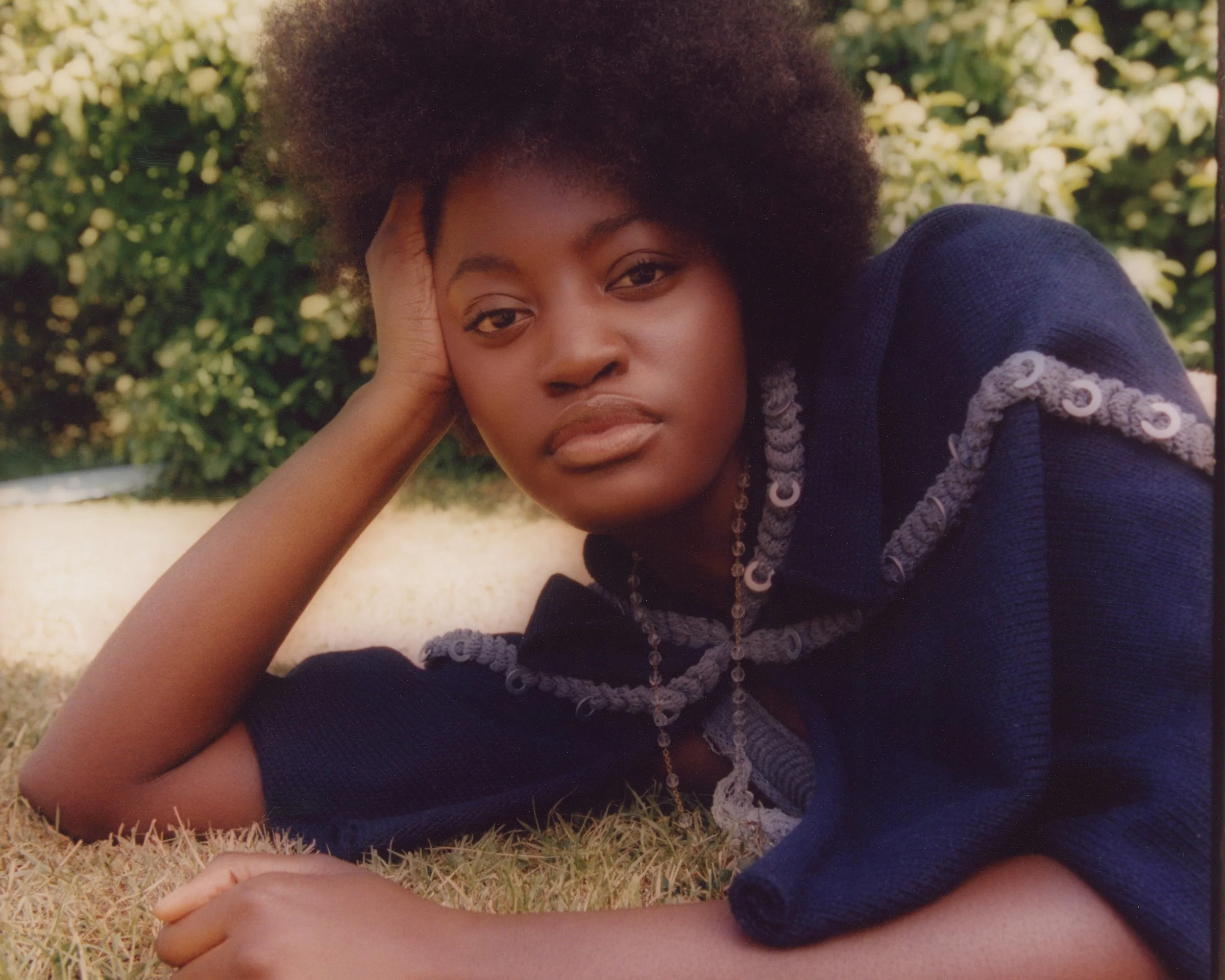 Avant-garde beauty styling: Monochromatic blue knitted garment and matching jewelry.