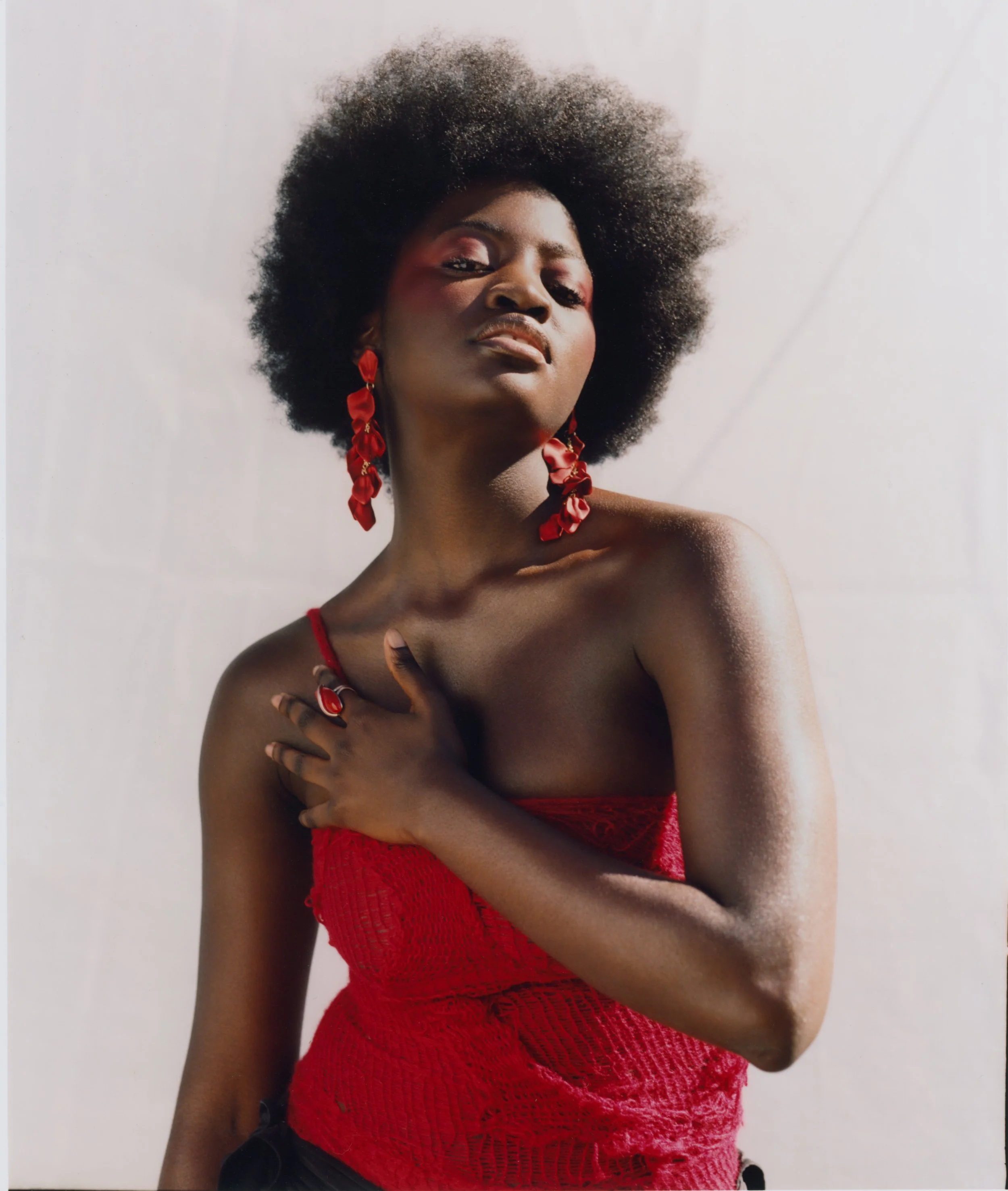 Saturated red textiles and artisanal hardware captured in high-contrast natural light.