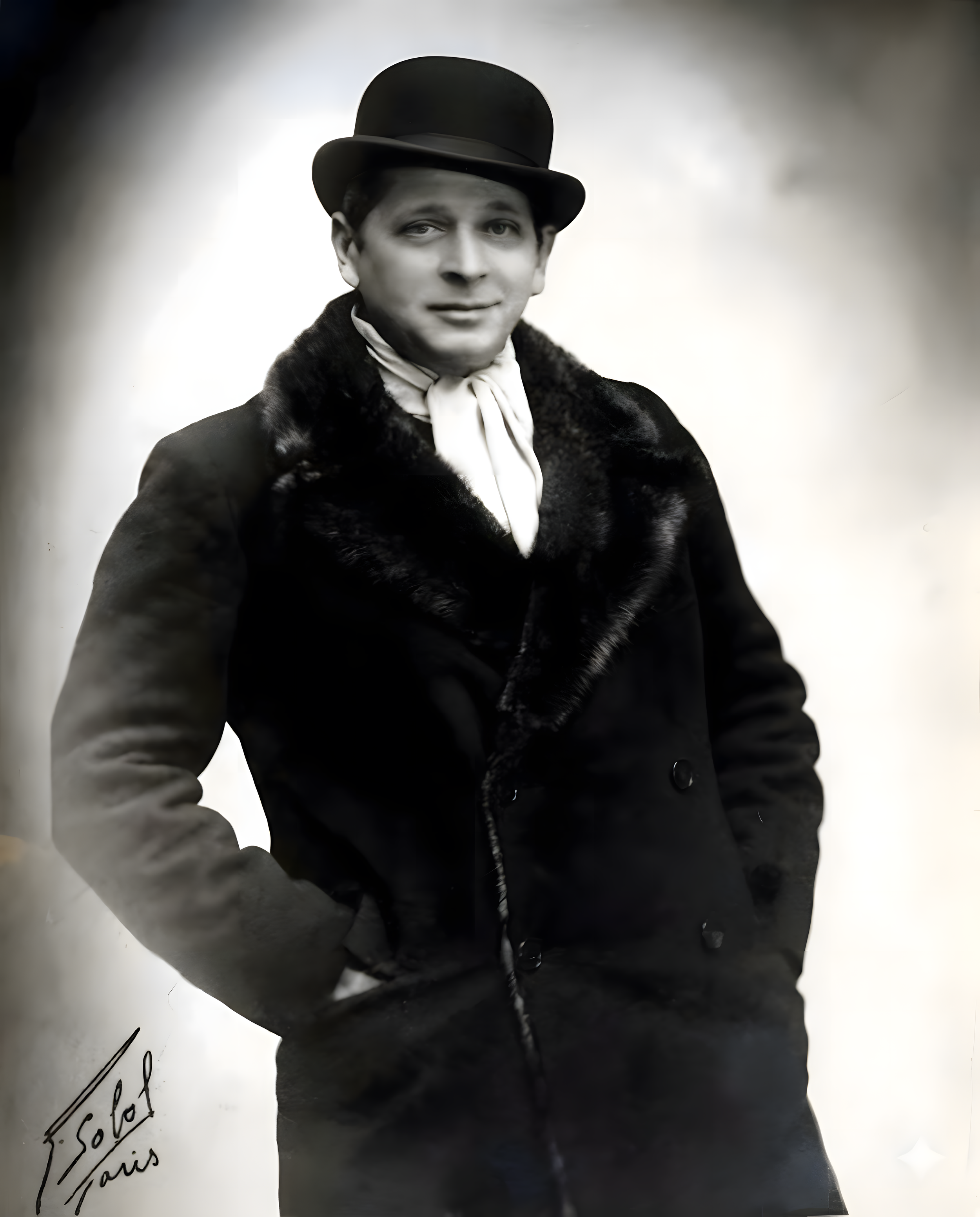 Un homme habillé avec un manteau en fourrure et un haut-de-forme, posé pour une photo en noir et blanc.