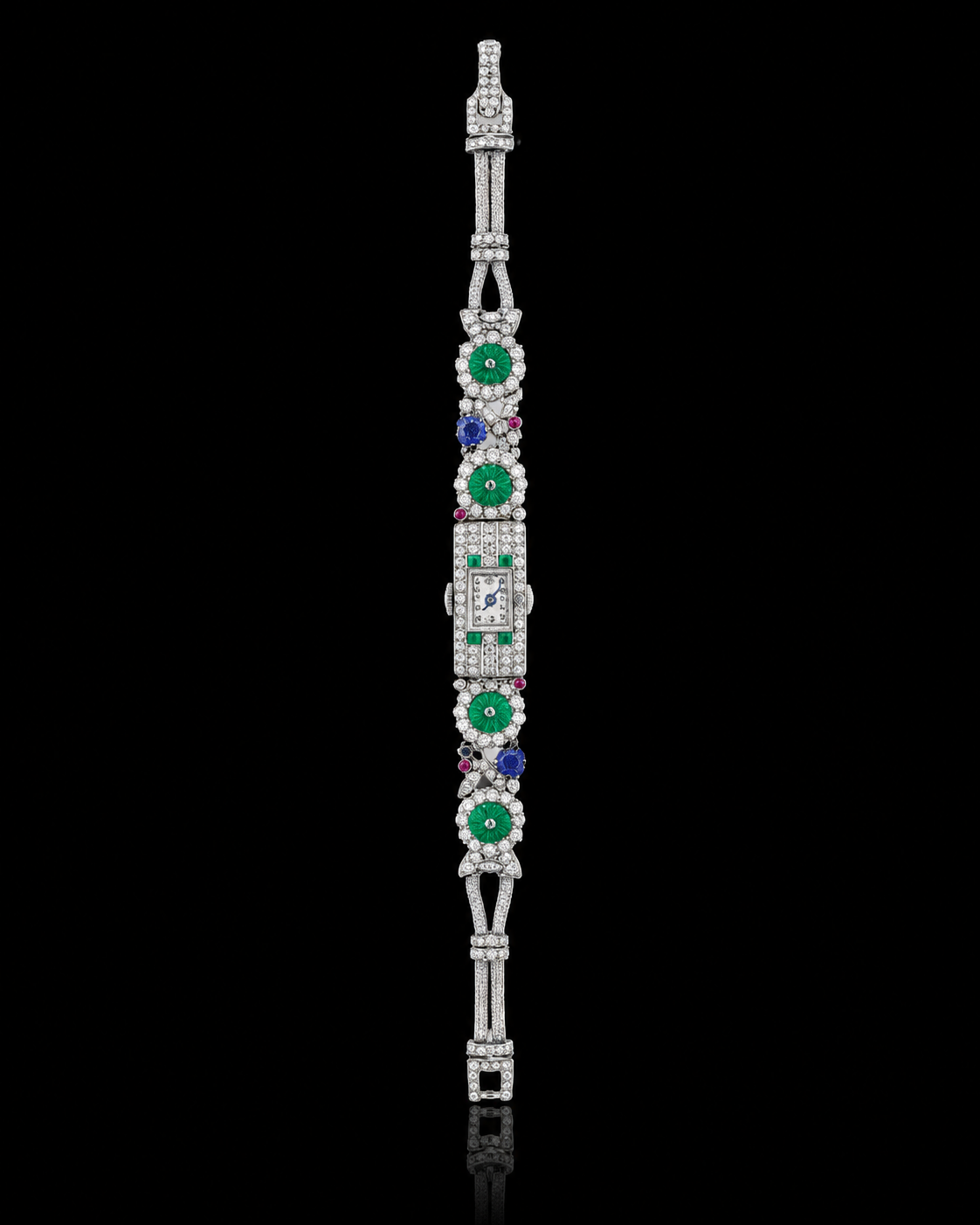 Bracelet vintage en or blanc orné de diamants, avec des pièces en émail vert et des pierres précieuses comme le saphir et le rubis, et un petit cadran de montre rectangulaire au centre.