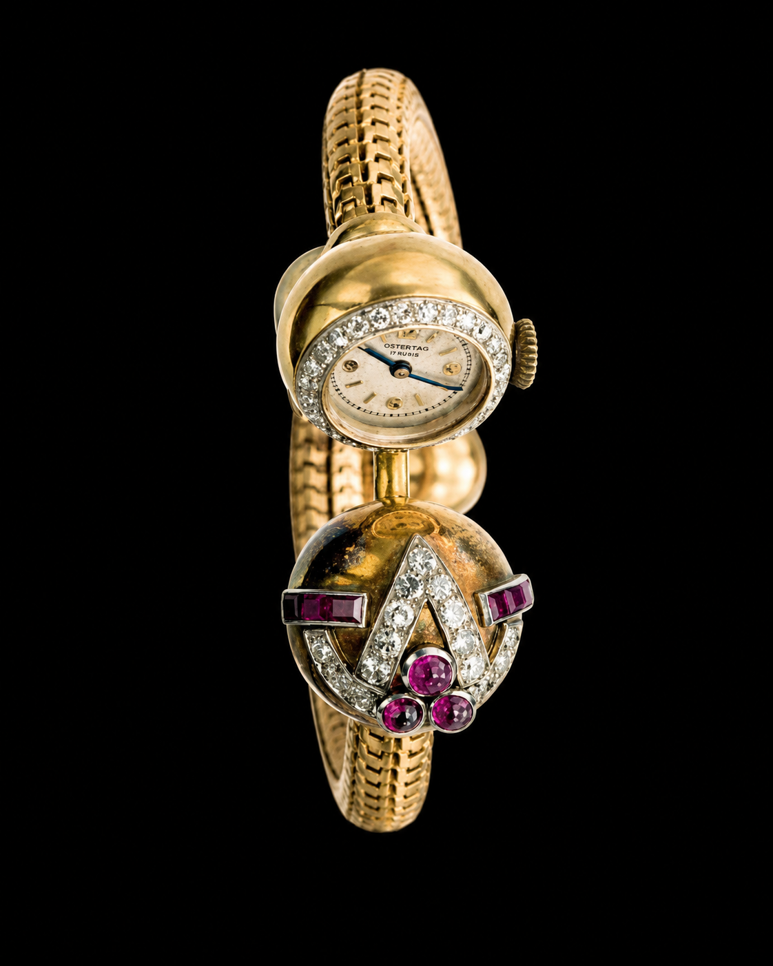 Montre bracelet en or avec cadran orné de diamants, ornement en forme de casque avec pierres précieuses rouges et diamants, fond noir.