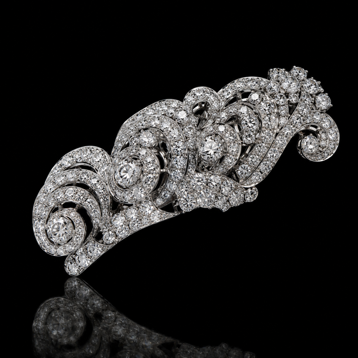 Broche en métal argenté ornée de nombreux petits diamants et orné de spirales décoratives, sur fond noir.
