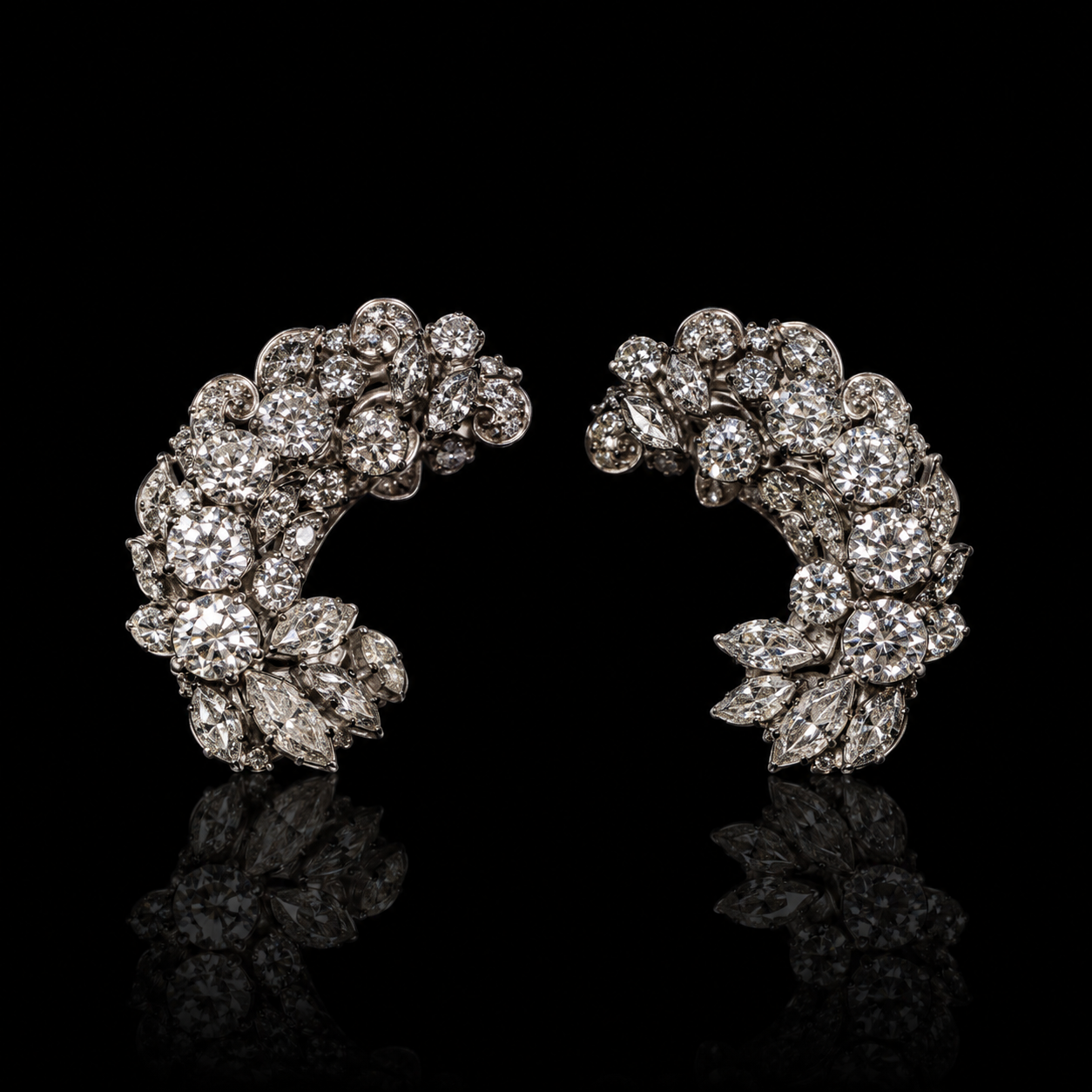 Une paire de boucles d'oreilles en or blanc ornées de diamants, disposées en cercle sur un fond noir.