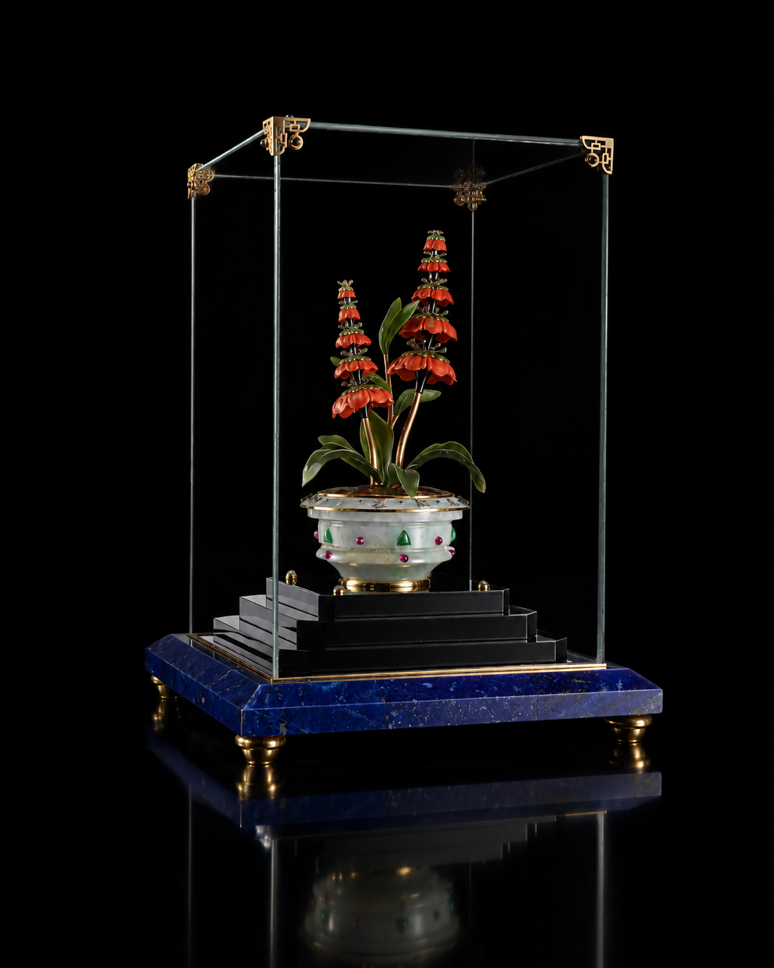 Une pièce de collection avec une plante en pot, sous une structure en verre et en métal avec une base en pierre bleue et des ornements dorés.