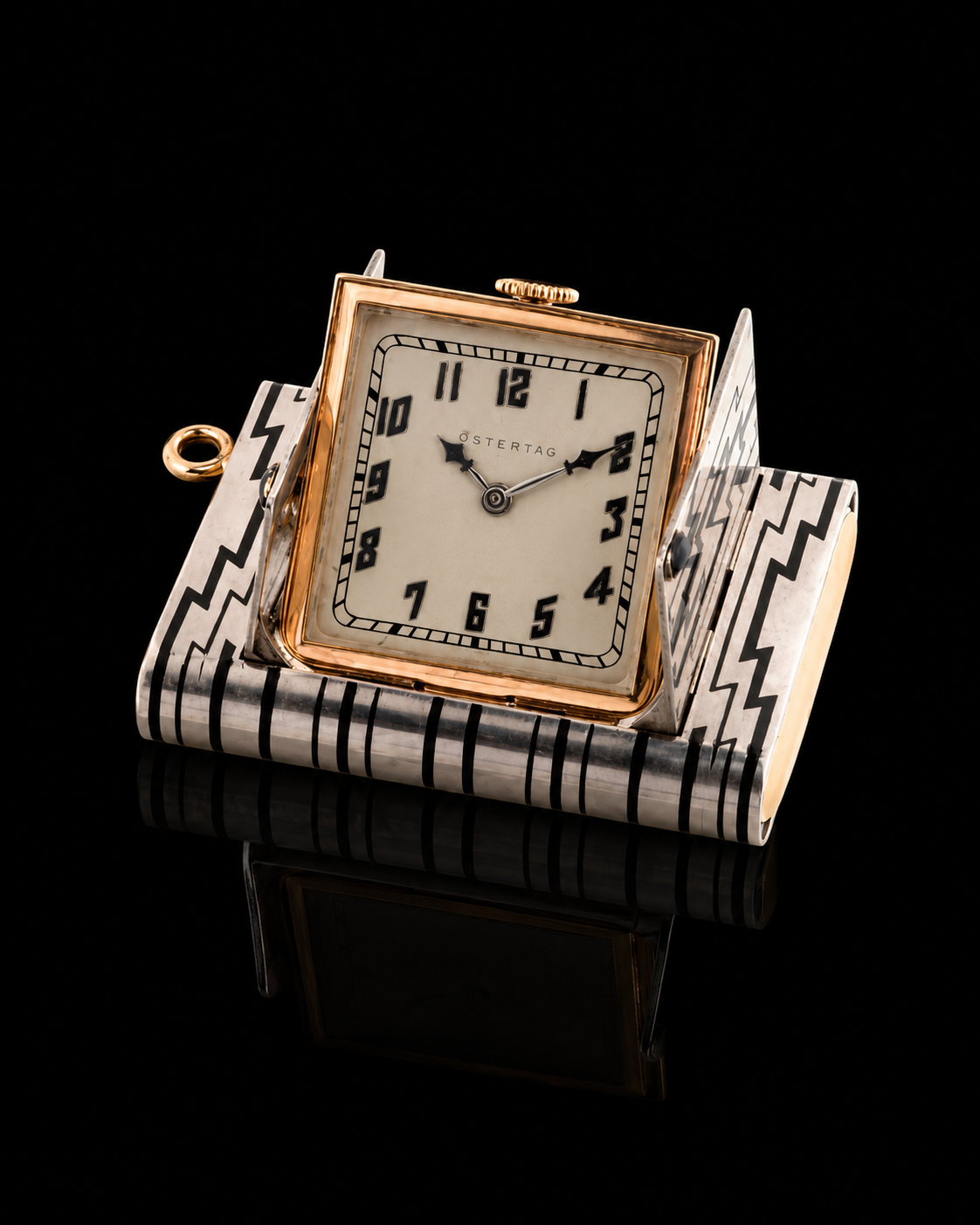 Montre de voyage vintage avec un cadran rond, entourée d'un boîtier en métal avec un motif géométrique noir et blanc, sur fond noir, reflétée sur une surface brillante.