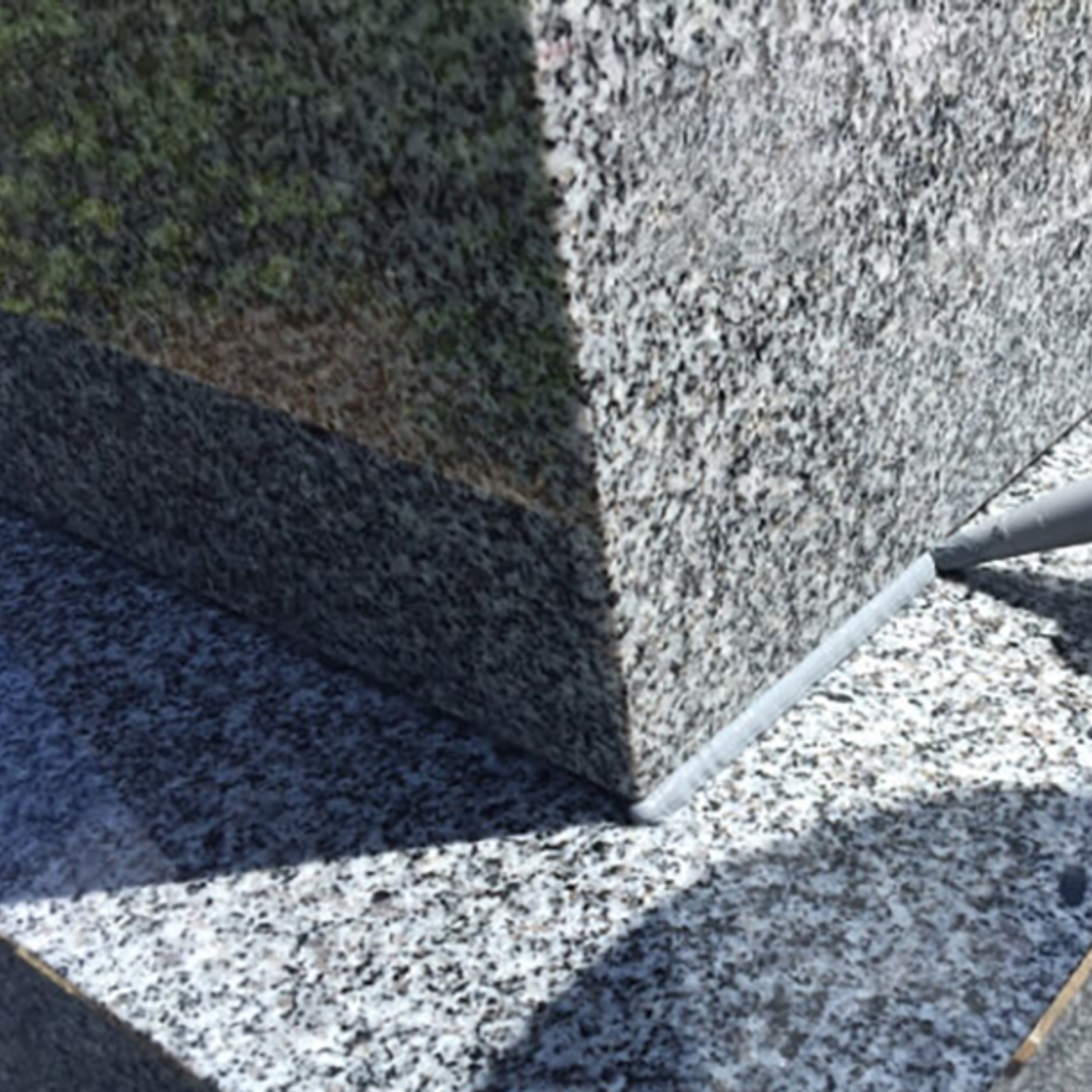 Zoom photo sur une application de joint silicone autour d'une tombale.