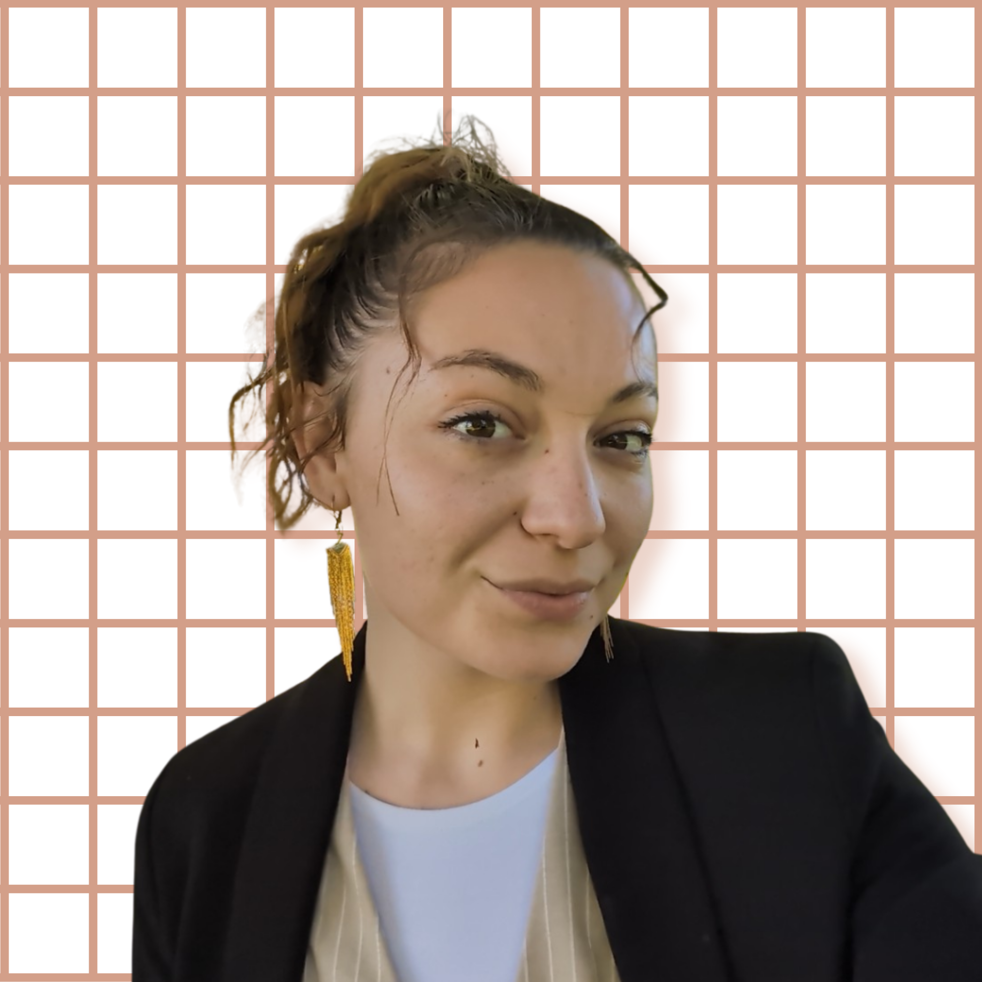 Une jeune femme souriant, portant des boucles d'oreilles longues de couleur jaune, vêtue d'une veste noire et d'une t-shirt blanc, avec un fond blanc et une grille orange clair.