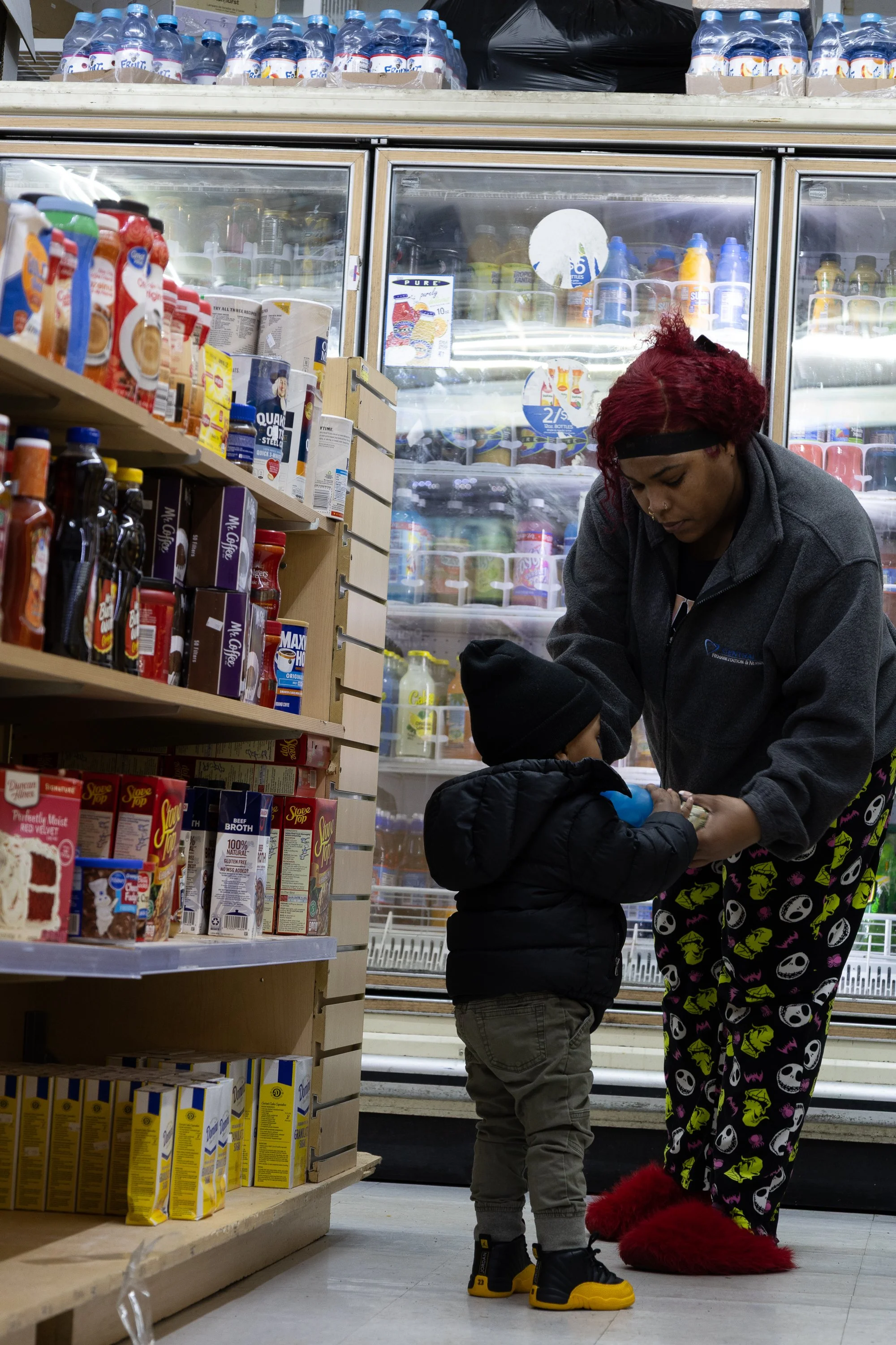  A woman helps a child reach for an item on a shelf inside Ze Mart on Jan. 10, 2026. Photo by: Destinyi Fernandez 