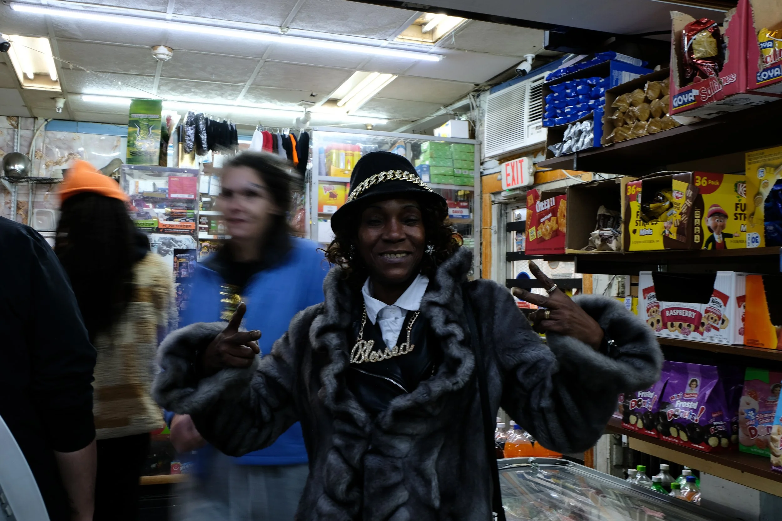  A woman gives a peace sign for the camera inside Ze Mart on Jan. 17, 2026, as other patrons move through the store in the background. Photo by: Micah Orieta 
