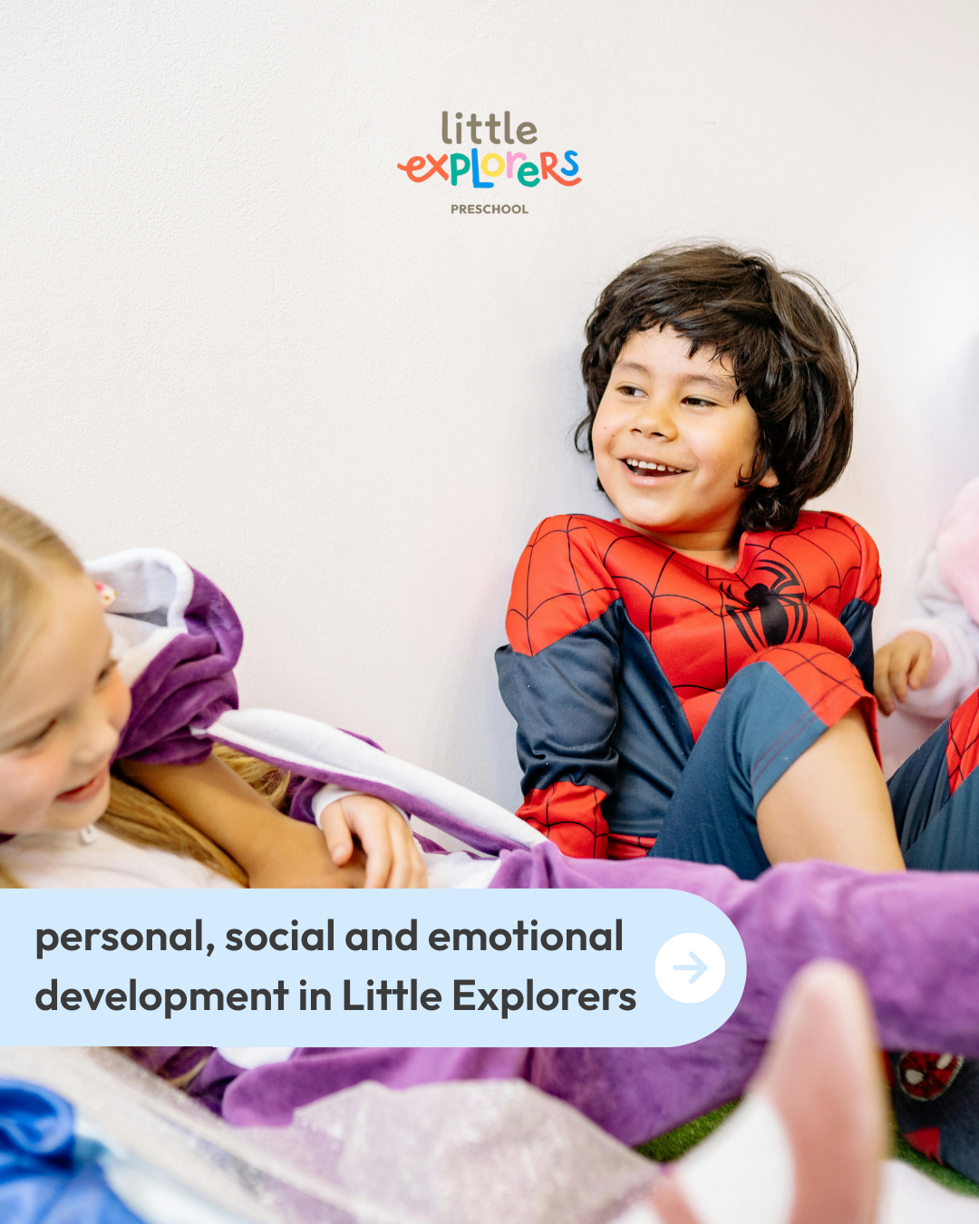 Children in a preschool classroom, with a boy in a Spider-Man costume smiling and interacting with peers, for promoting personal, social, and emotional development in Little Explorers preschool.