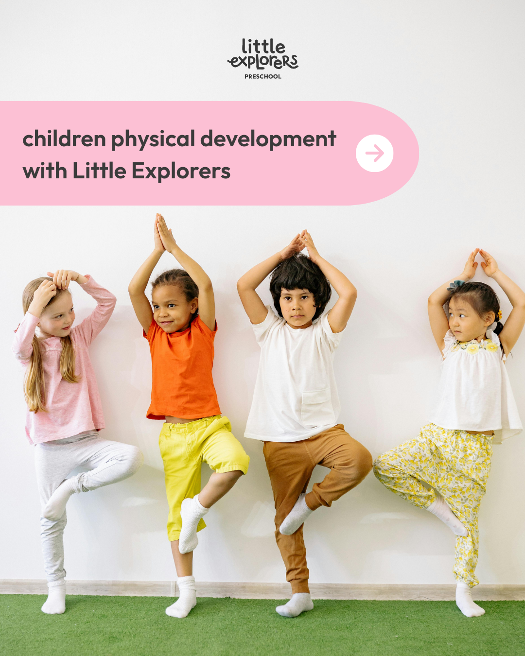 Four young children standing on one leg with their hands together above their head in a yoga pose, against a white wall. Four children are dressed casually, with a pink, orange, white, and yellow clothing.