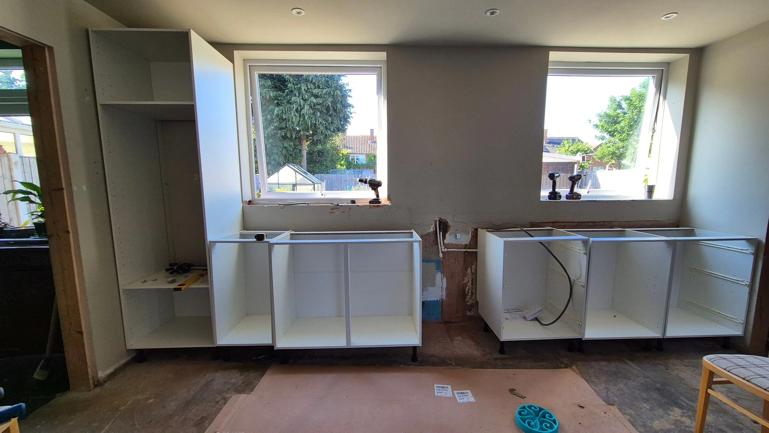 A work-in-progress kitchen renovation with unfinished cabinets and tools.