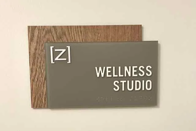 Sign reading '[z] WELLNESS STUDIO' mounted on a wall.