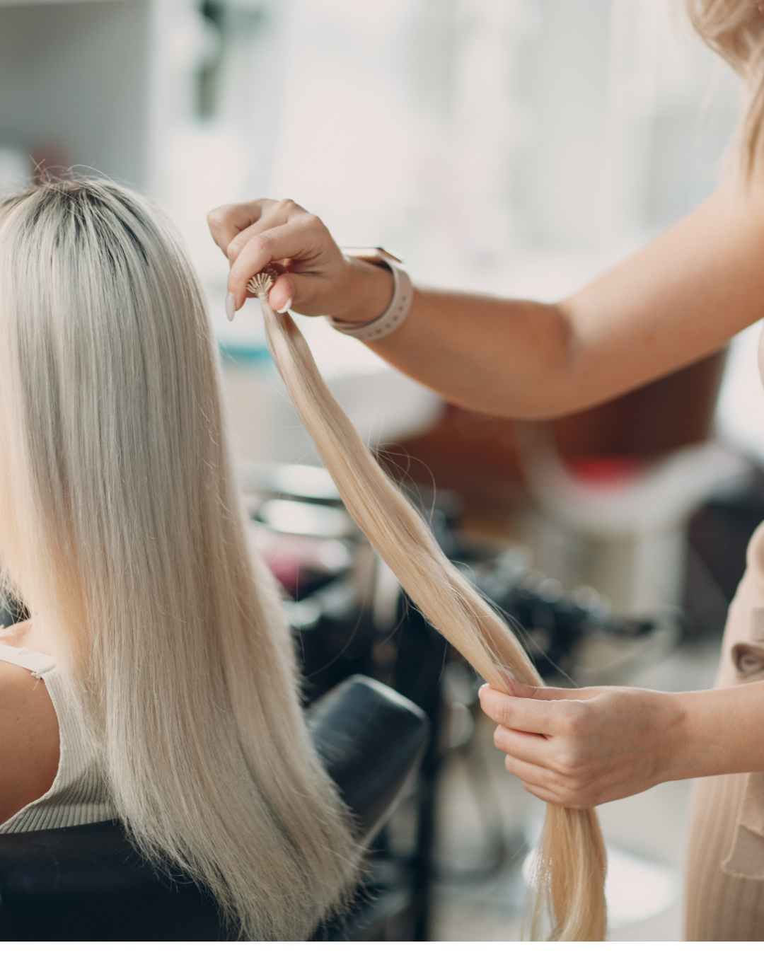 A person with blonde hair getting their hair styled by a hairstylist.