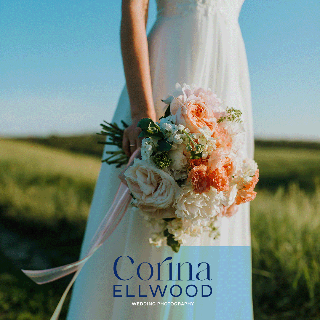 A bride holding a bouquet of pink and white flowers outdoors with a blurred green landscape in the background. Text overlay reads "Corina Ellwood Wedding Photography."