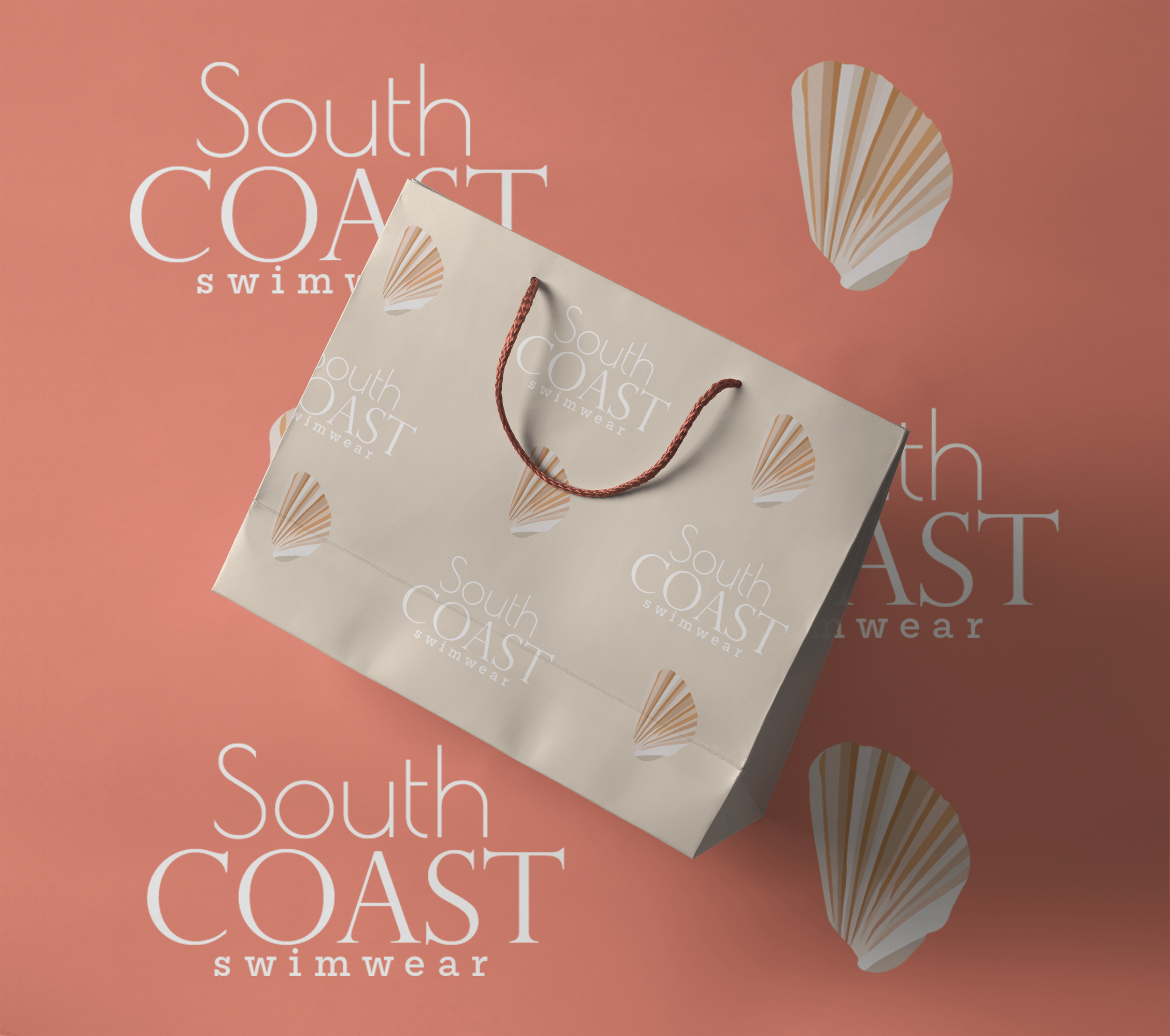 A promotional display with the text 'South Coast Swimwear' on a pink background, featuring a shopping bag with seashell designs and a rope handle, and a shell illustration in the background.