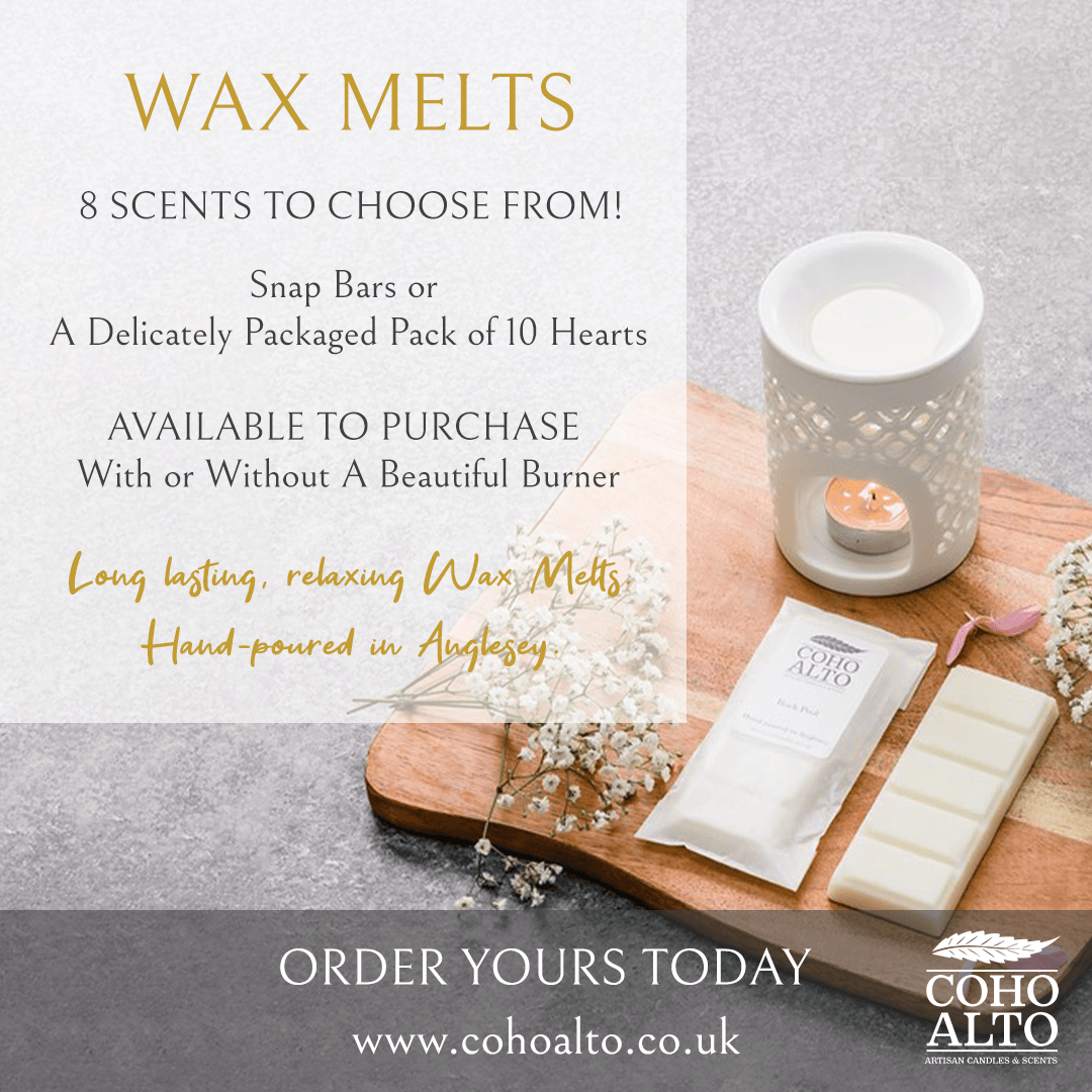 Image of a candle holder with a lit candle, a packet of Coho Alto scented wax, a white chocolate bar, and sprigs of white flowers on a wooden board, with promotional text for wax melts.