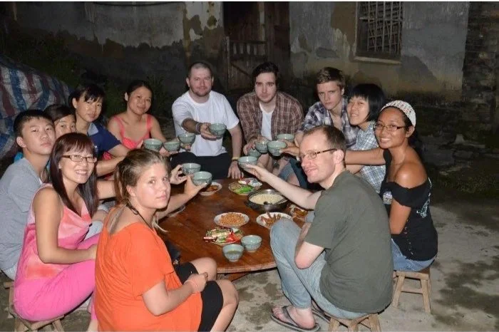 Dobrovolníci u tradičního oběda v zahraničí – budování přátelství a komunitní život na studentských stážích.