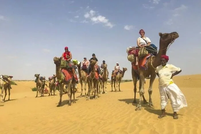 Autentický zážitek z cestování v exotických destinacích – jízda na velbloudech v poušti s místním průvodcem.