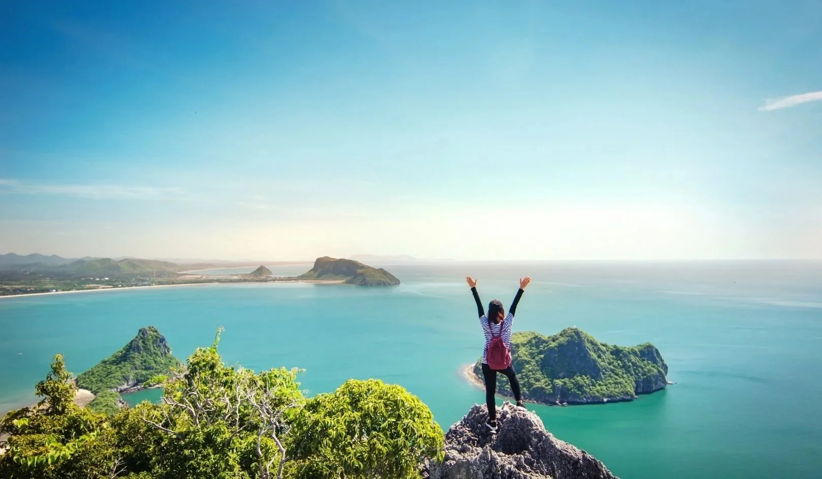 	
Dobrovolnice objevuje exotické ostrovy v rámci mezinárodního programu pro studenty – pohled na oceán a zelenou krajinu.