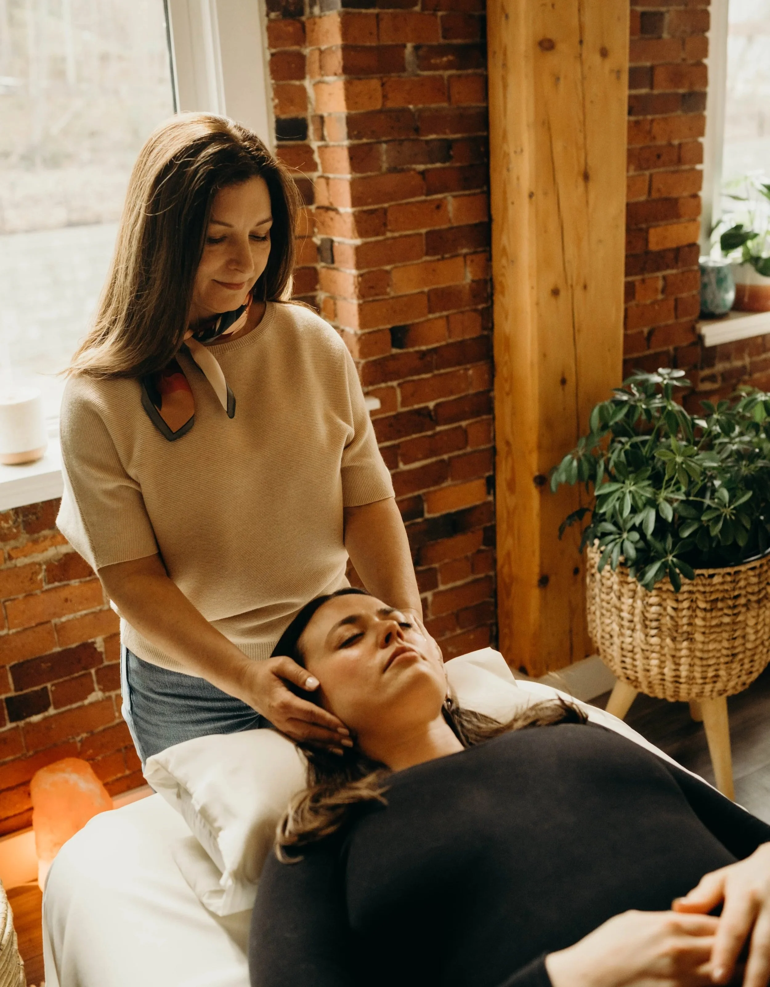 Kristie LaRocca providing an energy healing session with a client at her Rollinsford, NH office, offering holistic energy healing and intuitive guidance for greater clarity and transformation.